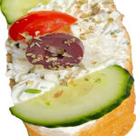 Frisch belegtes Brötchen mit Schafkäse, Oliven, Tomaten, Gurke, Kräuteraufstrich; Schafkäse