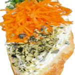 Frisch belegtes Weißbrötchen mit Karotten, Kürbiskerne, Schnittlauch, Kräuteraufstrich.