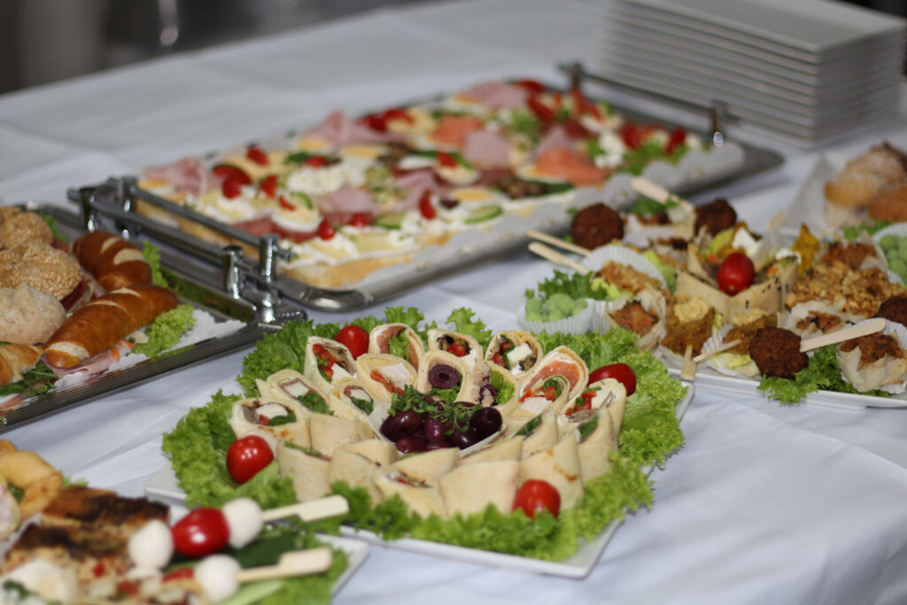 Buffettisch mit Fingerfood, belegten Brötchen, Snacks und Desserts für Gäste bei einer Feier