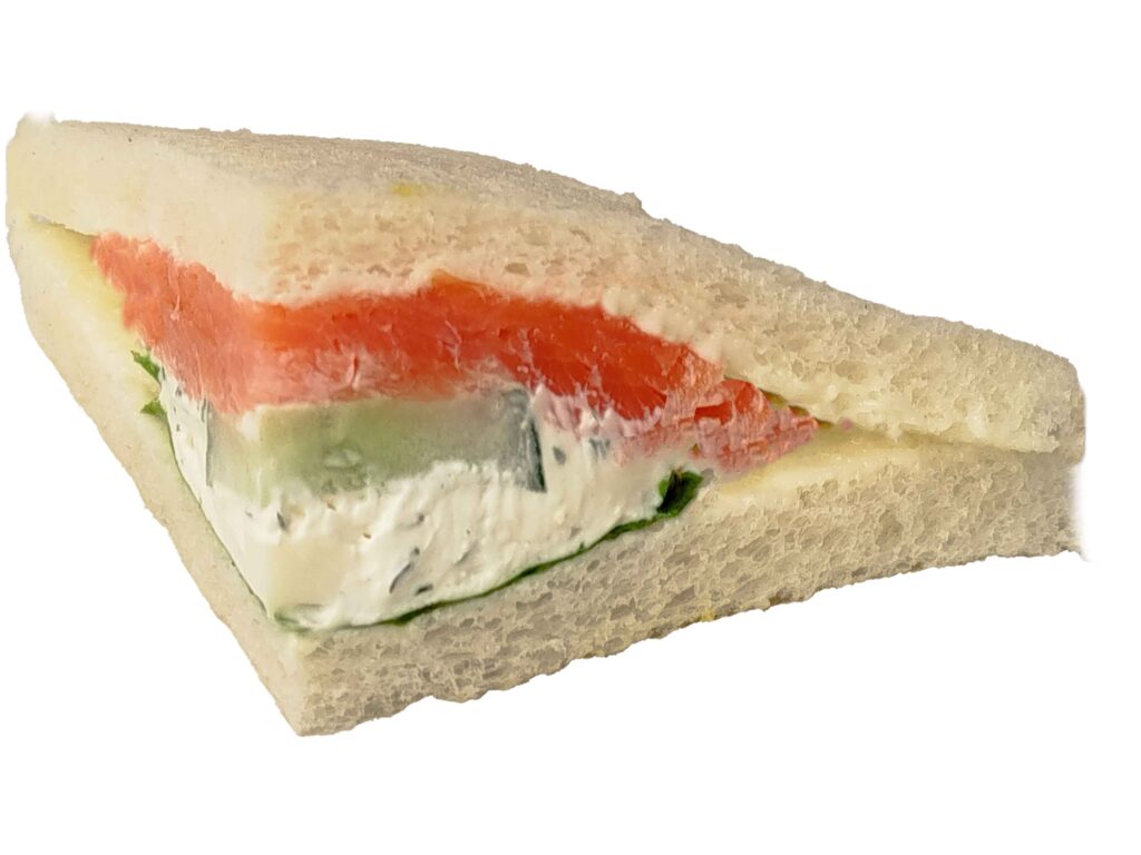 Edles Tramezzini, belegt mit Graved Lachs, gekochtem Ei, Gurke, Rucola und Kräuteraufstrich.