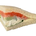 Edles Tramezzini, belegt mit Graved Lachs, gekochtem Ei, Gurke, Rucola und Kräuteraufstrich.